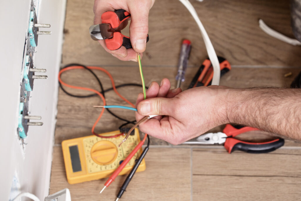 A worker performing maintenance on electrical wiring