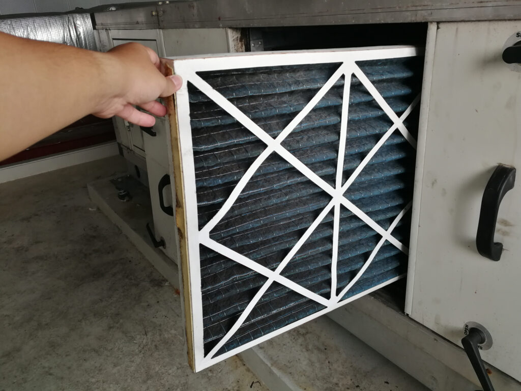 An air filter being removed from an air conditioning unit
